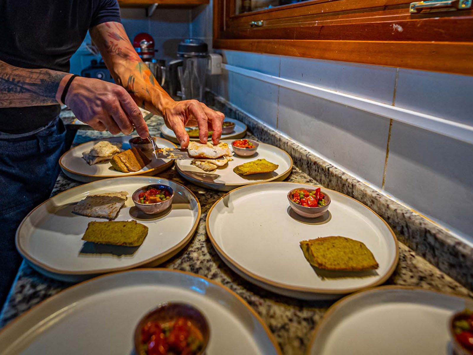 Our chef prepping seven plates of appetizers 